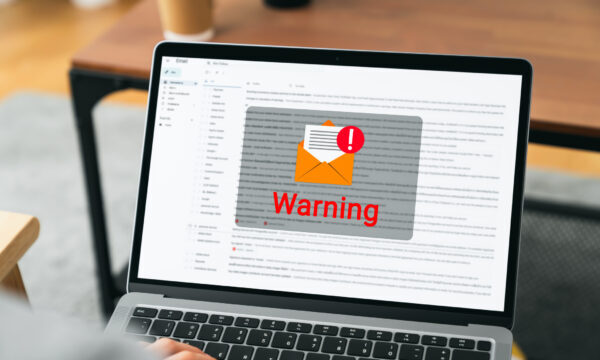 Hand using laptop with shows a warning screen of new email notifications, hack password and personal data. Concept of cyber crime